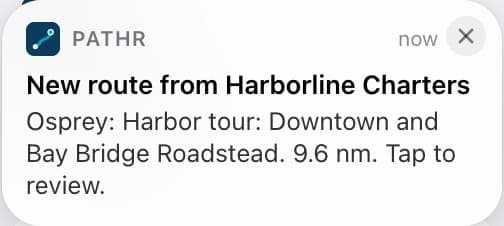 The route arriving on the captain's simulated phone: a Pathr notification, New route from Harborline Charters. Osprey: Harbor tour: Downtown and Bay Bridge Roadstead. 9.6 nm. Tap to review.